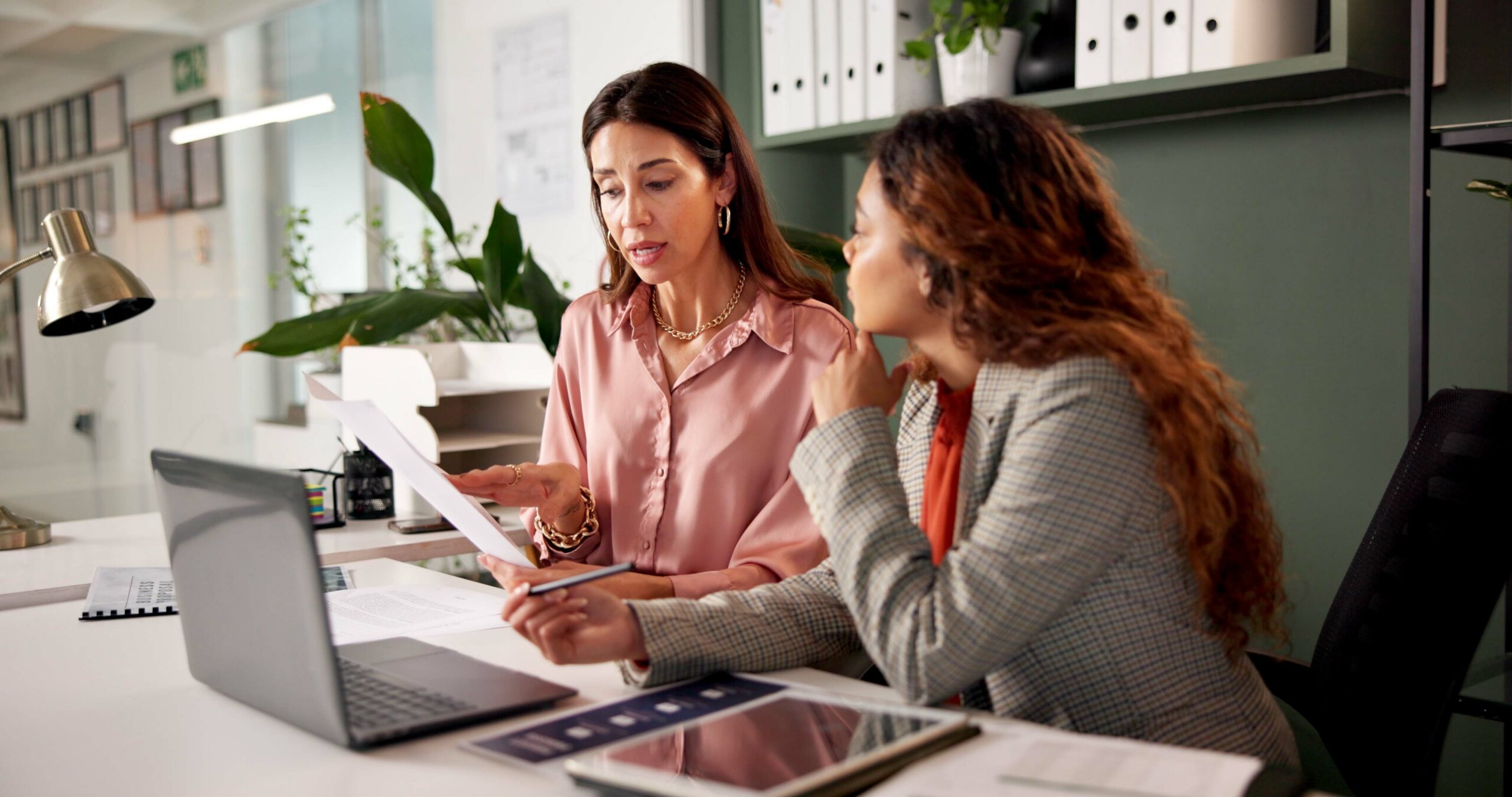 Two professionals reviewing SOC 2 audit documentation at an office desk