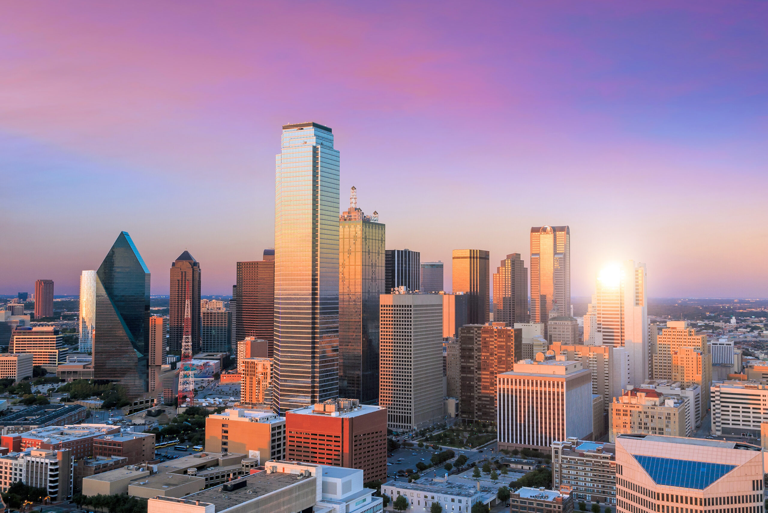 Dallas skyline at dusk with the Bank of America Plaza tower, home to Moore Colson's Dallas business valuation clients.