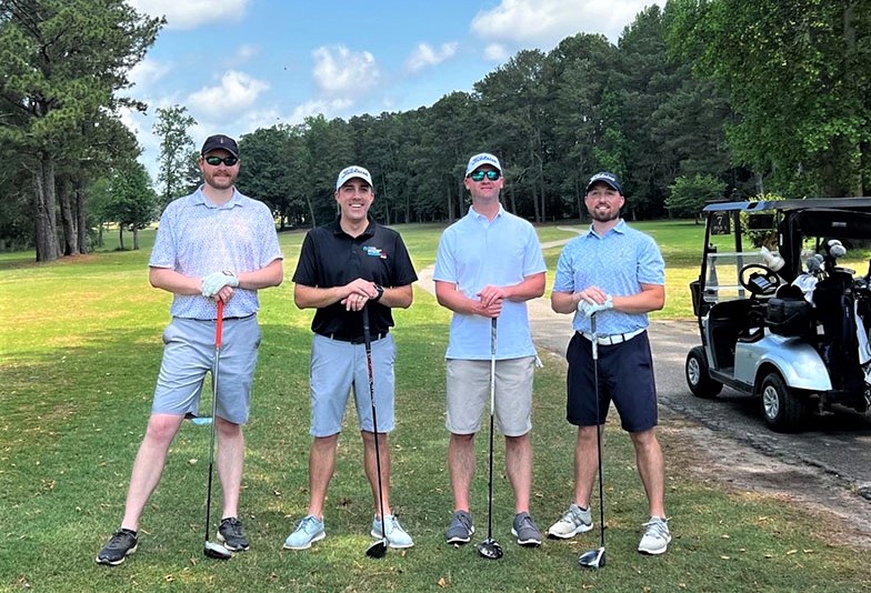4 men posing at golf course